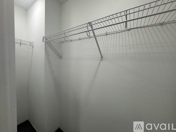 A white walk in closet with shelving.