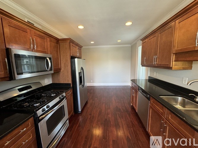 A kitchen with wooden cabinets and black countertops.