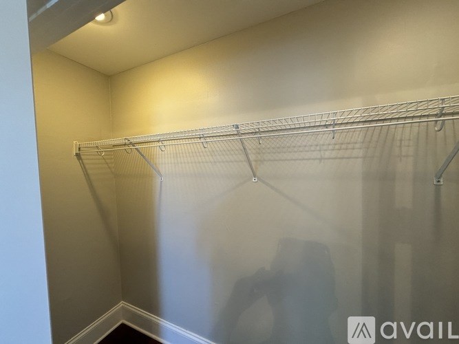 A white closet with a metal rack on the wall.