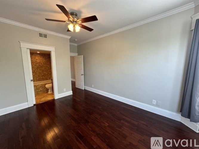 A room with a ceiling fan and wooden floors.