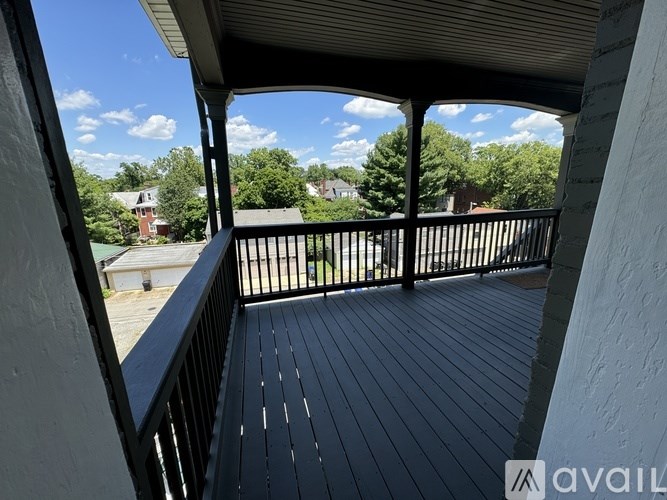 A balcony with a black railing and wooden floor.
