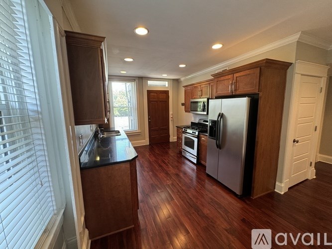 A kitchen with wooden cabinets and a black countertop.
