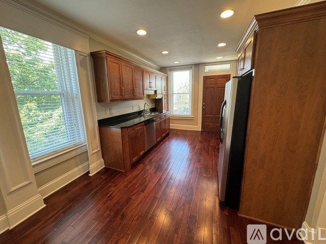 A kitchen with wooden floors and cabinets.