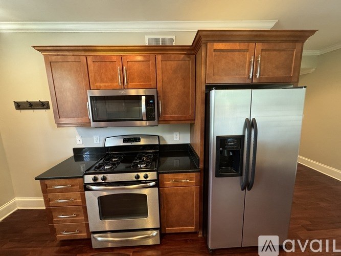 A kitchen with a black countertop and stainless steel appliances.
