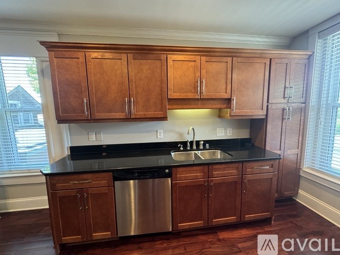 A kitchen with wooden cabinets and a black countertop.