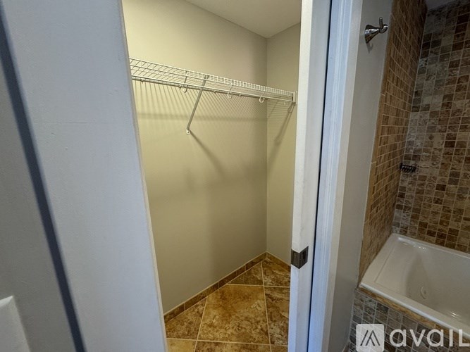 A white door is open to a bathroom with a tiled shower.