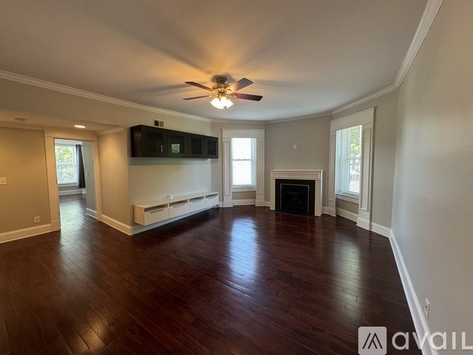 A living room with wood floors and a ceiling fan.