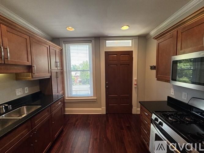 A kitchen with wooden cabinets and a black stove top oven.