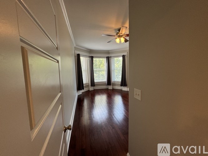 A room with a wooden floor and a ceiling fan.
