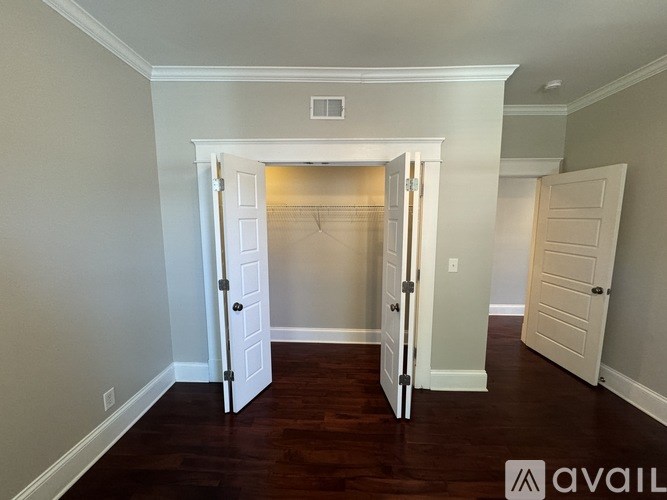 A room with a white door and a wooden floor.