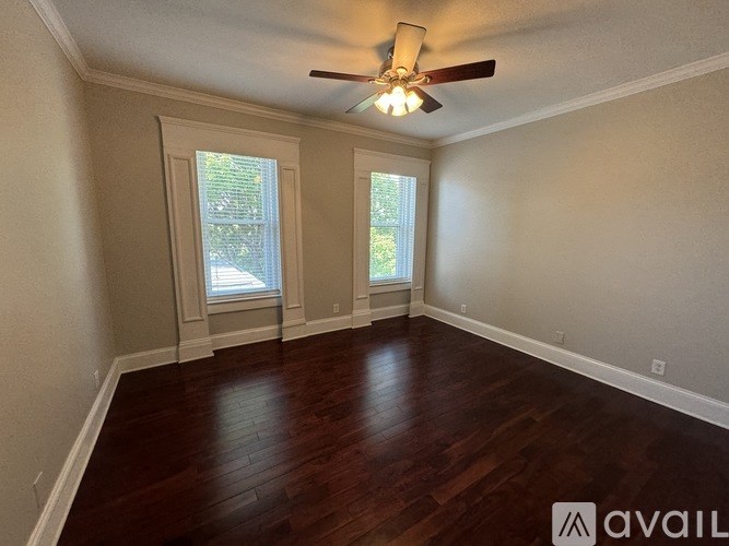 A room with wooden floors and a ceiling fan.