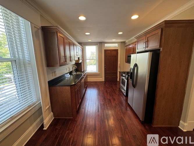 A kitchen with wooden cabinets and a refrigerator.