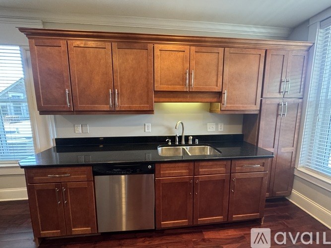 A kitchen with wooden cabinets and a black countertop.