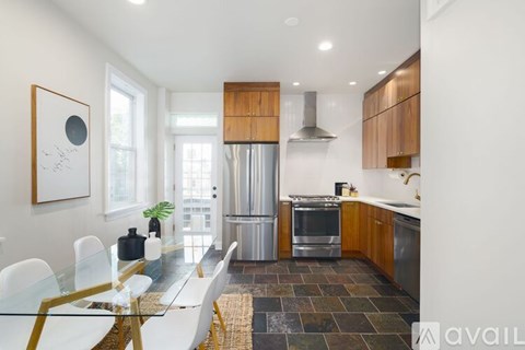 A modern kitchen with a glass dining table and chairs.
