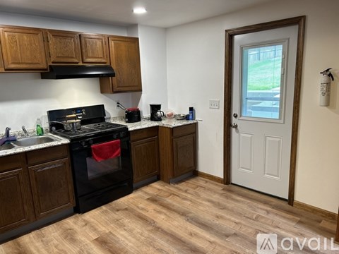 A kitchen with wooden cabinets and a black stove top oven.