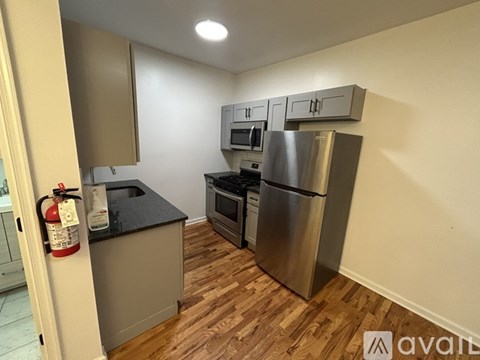A kitchen with a stainless steel refrigerator, oven, and microwave.
