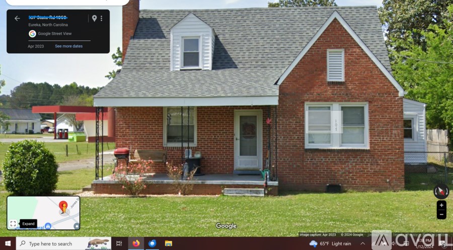 A red brick house with a white door and windows.