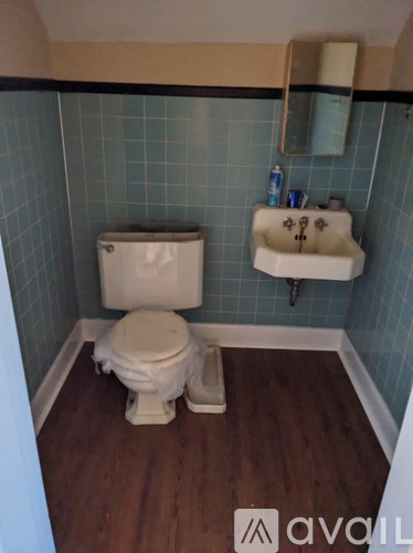 A white toilet and sink in a small bathroom.