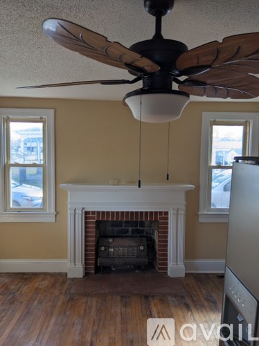 A room with a fireplace and a ceiling fan.