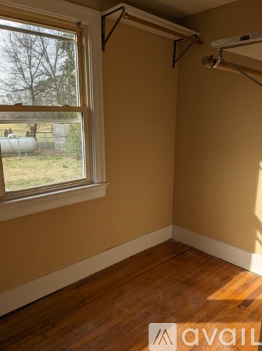 A room with a window and wooden floors.