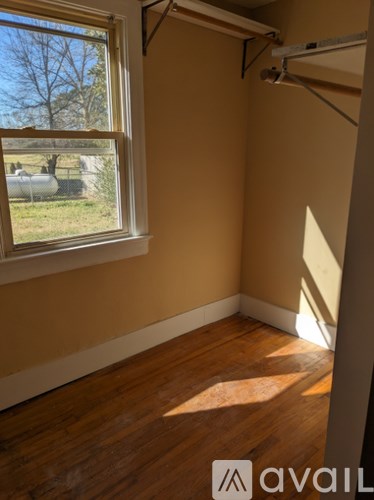 A room with a window and wooden floors.