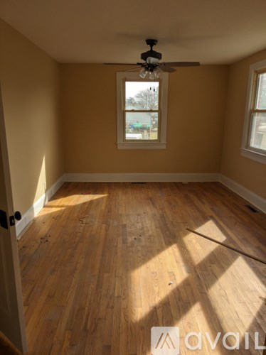 A room with wooden floors and a ceiling fan.