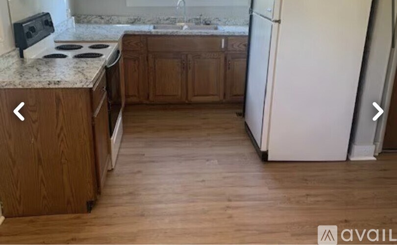 A kitchen with wooden cabinets and a white fridge.