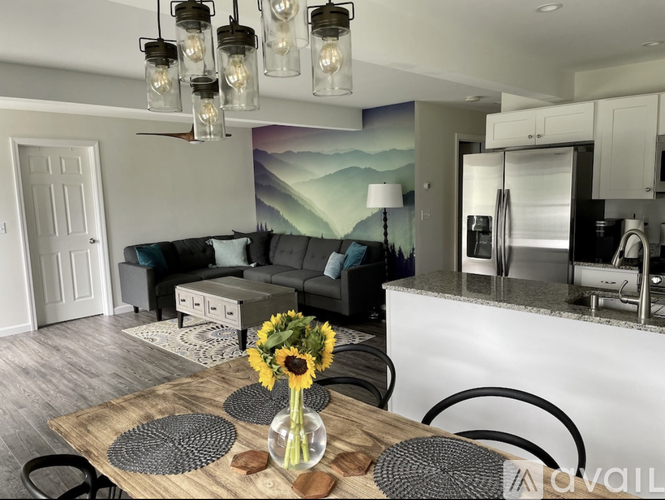 A modern kitchen with a dining table set for two.
