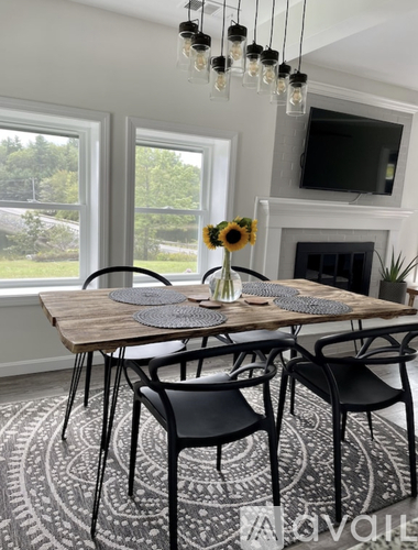 A dining room with a wooden table and chairs.