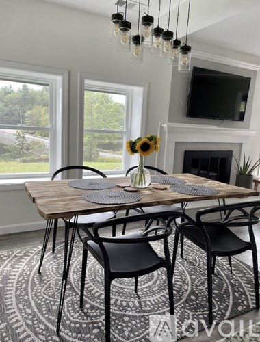 A dining room with a wooden table and chairs.
