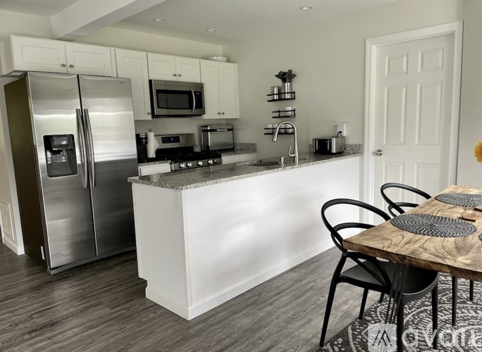 A kitchen with a white island and a refrigerator.