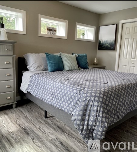 A bedroom with a bed, nightstand, and a dresser.