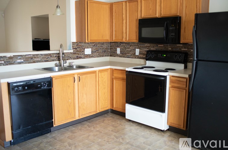 A kitchen with wooden cabinets and black appliances.