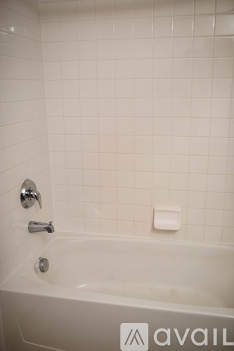 A white bathtub with a faucet and a soap dish.