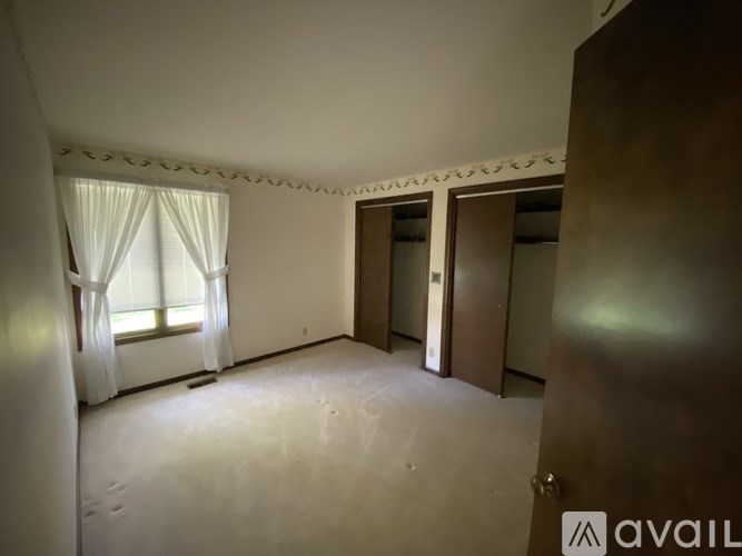 A room with a window and a door is available for rent.