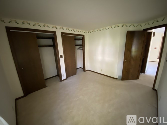 A room with a carpeted floor and a wall with a decorative border.