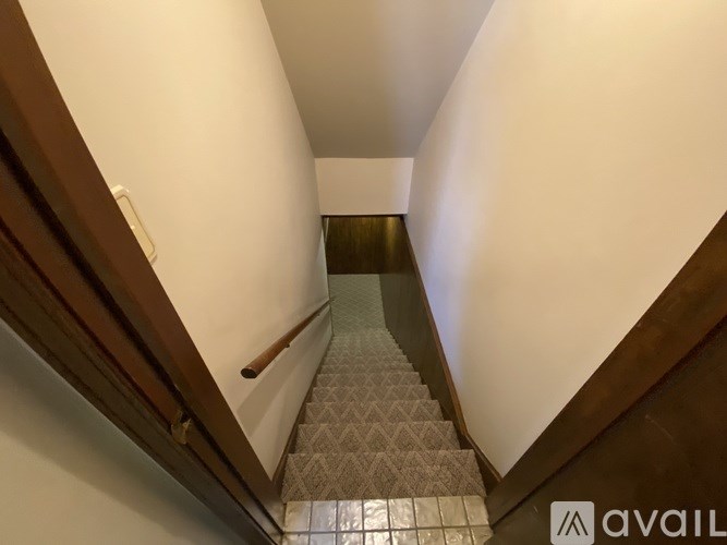 A staircase with a diamond patterned tread leads up to a landing.