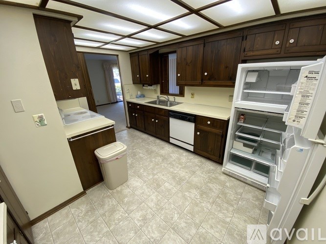 A kitchen with brown cabinets and a white fridge.