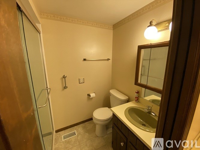 A bathroom with a toilet, sink, and shower.