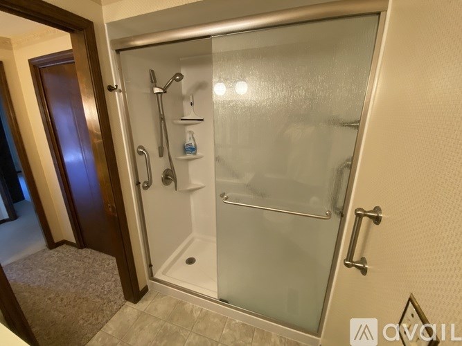A glass shower stall with a door and a glass door.