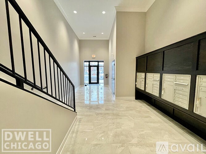 A hallway with a black railing and a white wall.