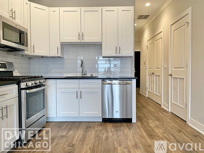 A kitchen with white cabinets and a stainless steel dishwasher.