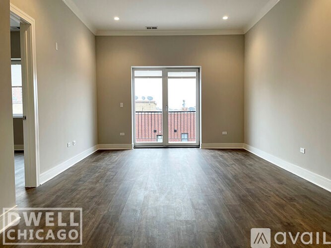 A spacious room with a view of a balcony through a sliding glass door.