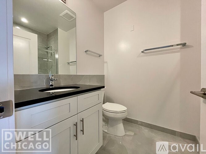A bathroom with a toilet, sink, and mirror.