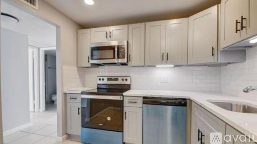 A kitchen with white cabinets and appliances.