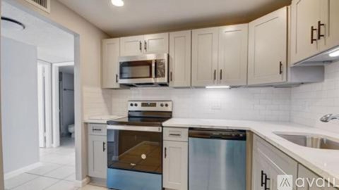 A kitchen with white cabinets and appliances.