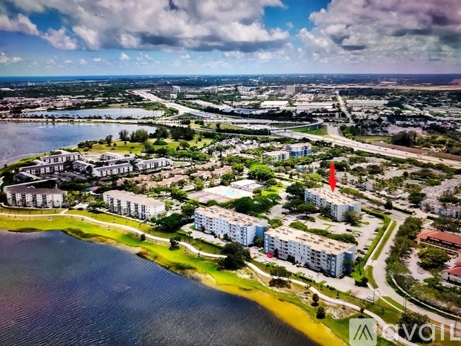 A bird's eye view of a coastal residential area with a large body of water and several buildings.