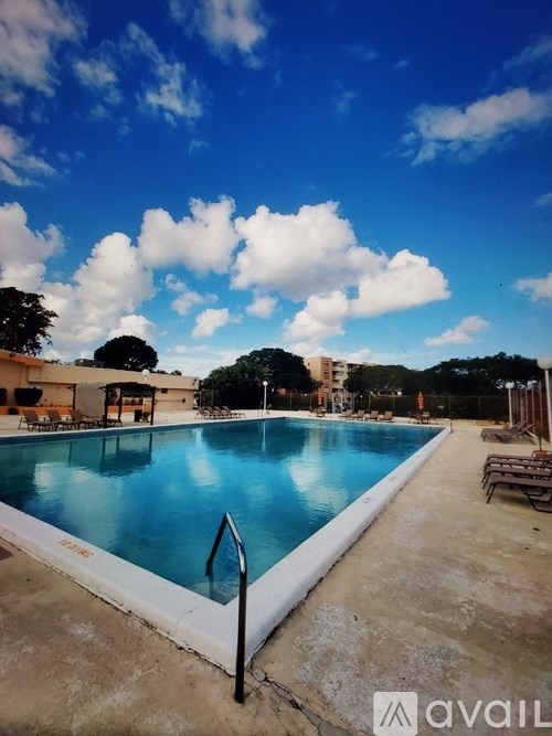 A swimming pool with a blue sky and clouds in the background.