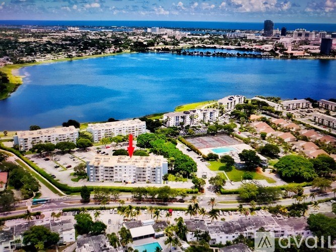 A red arrow points to a building in a city with a large body of water.