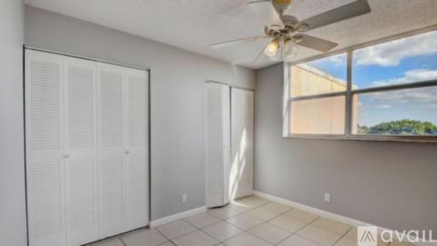 A room with a ceiling fan and sliding doors.